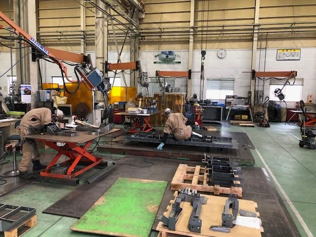 防護面を装着した作業者が金属部材の継ぎ目を溶接している手元